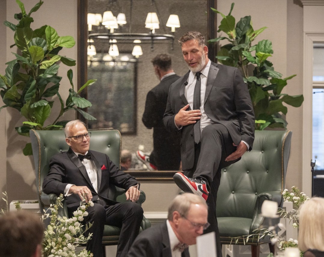 Russ Tanner, emcee at the 2026 St. Mary’s Celebration of Courageous Leaders Gala, showing off his shoes. (Photo Credit: Wingate Downs)