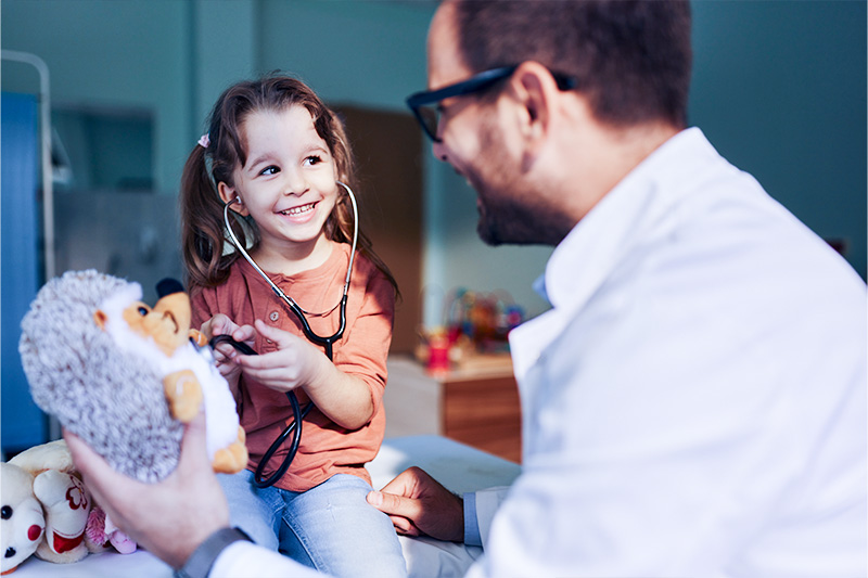 How to prevent RSV in children? | Picture of a child and doctor practicing taking vitals on a stuffed animal.